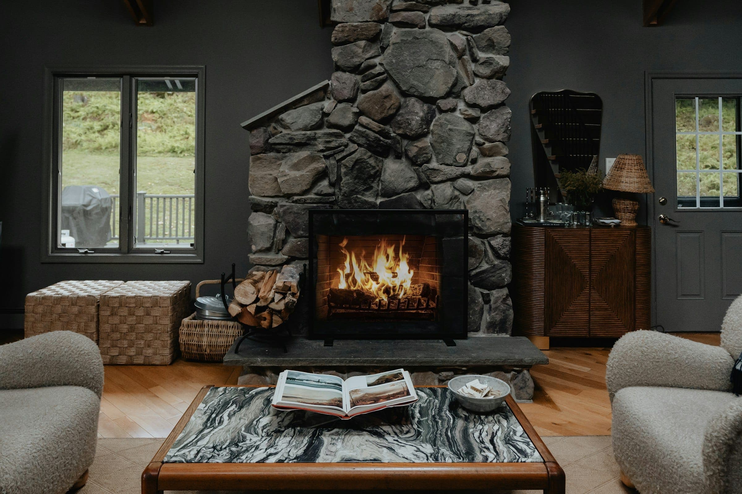 Stone fireplace wall in a dark living room with a marble coffee table